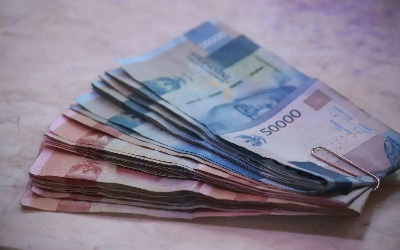 Indonesian rupiah cash remains useful for arrivals, small vendors and backup payments Stack of Indonesian rupiah banknotes for travel cash planning